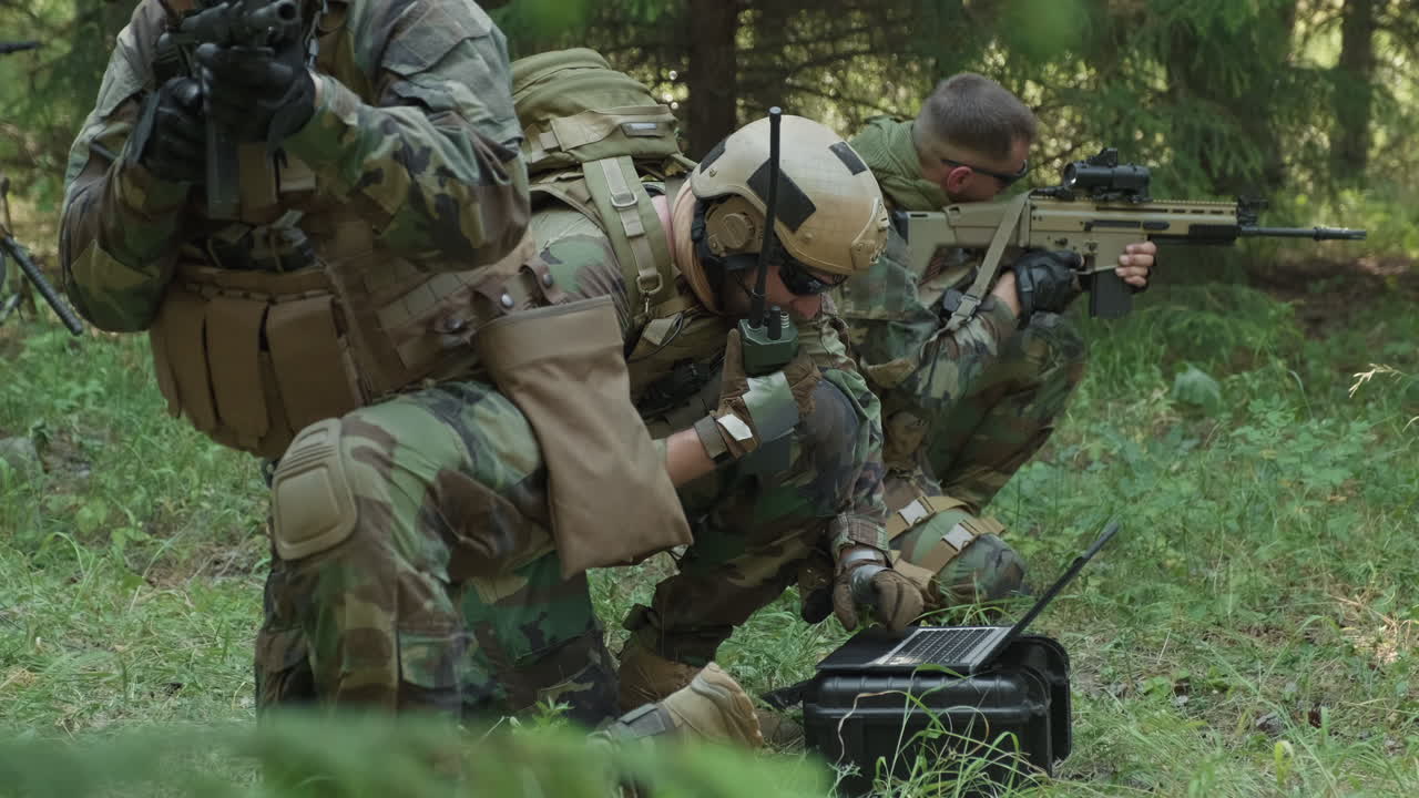 Special Forces Soldiers Using Laptop In Jungle