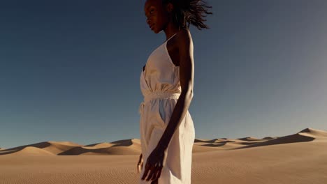 mujer con vestido blanco caminando por el paisaje del desierto