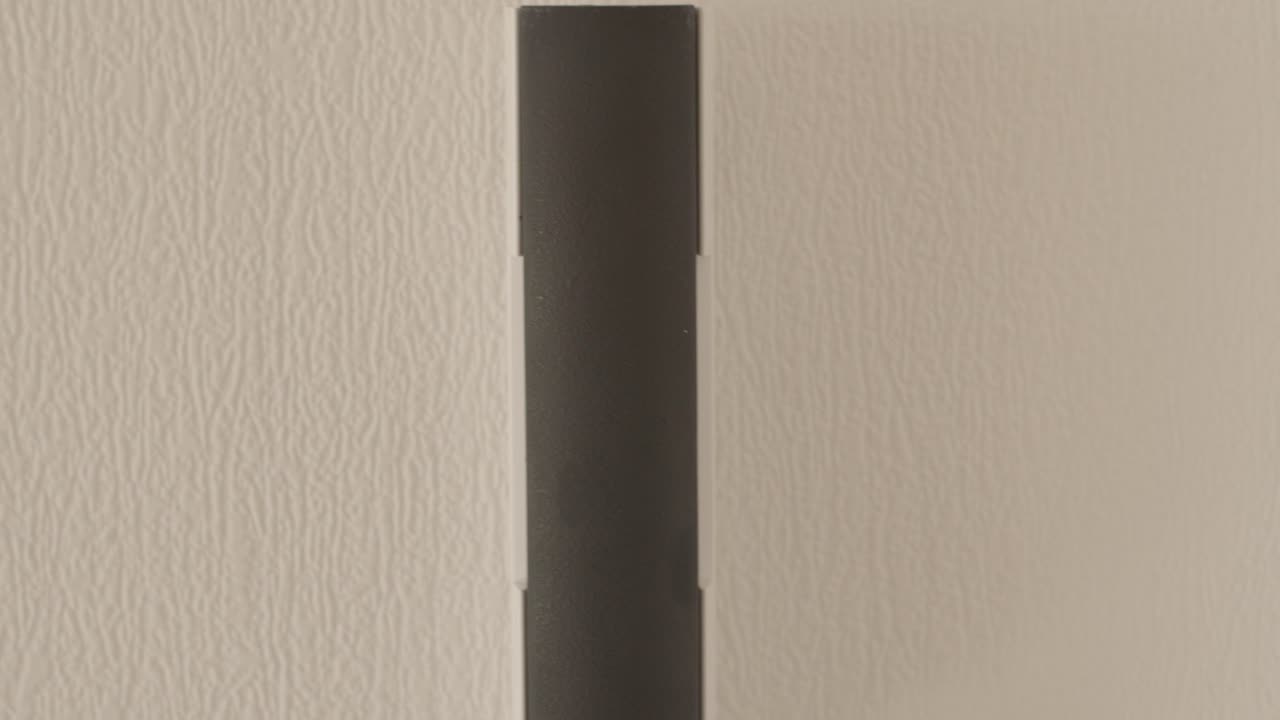 persona tocando un intercomunicador montado en la pared