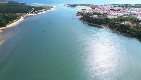 aerial-view-over-small-coastal-town,-blue-ocean,-red-roofs,-4k