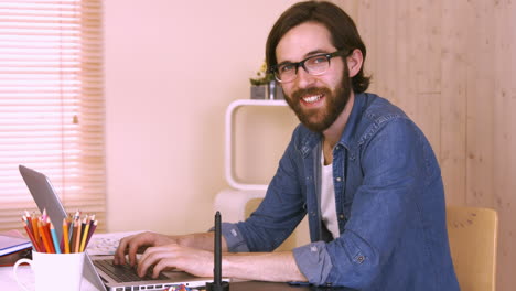 trabajador casual en su escritorio usando una computadora portátil