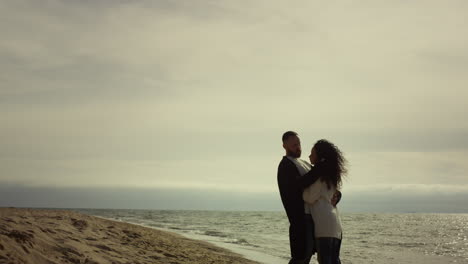 Pareja-De-Pie-En-La-Playa-Del-Mar-Con-Ropa-Informal.-Amantes-Abrazándose-En-Viaje-De-Vacaciones.