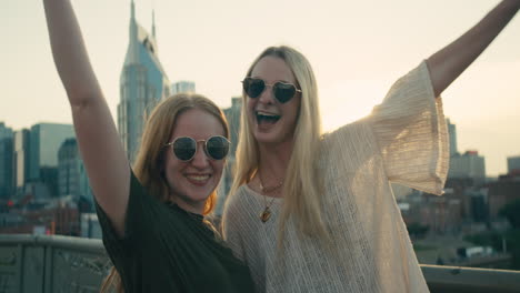Two women posing in front of a city skyline