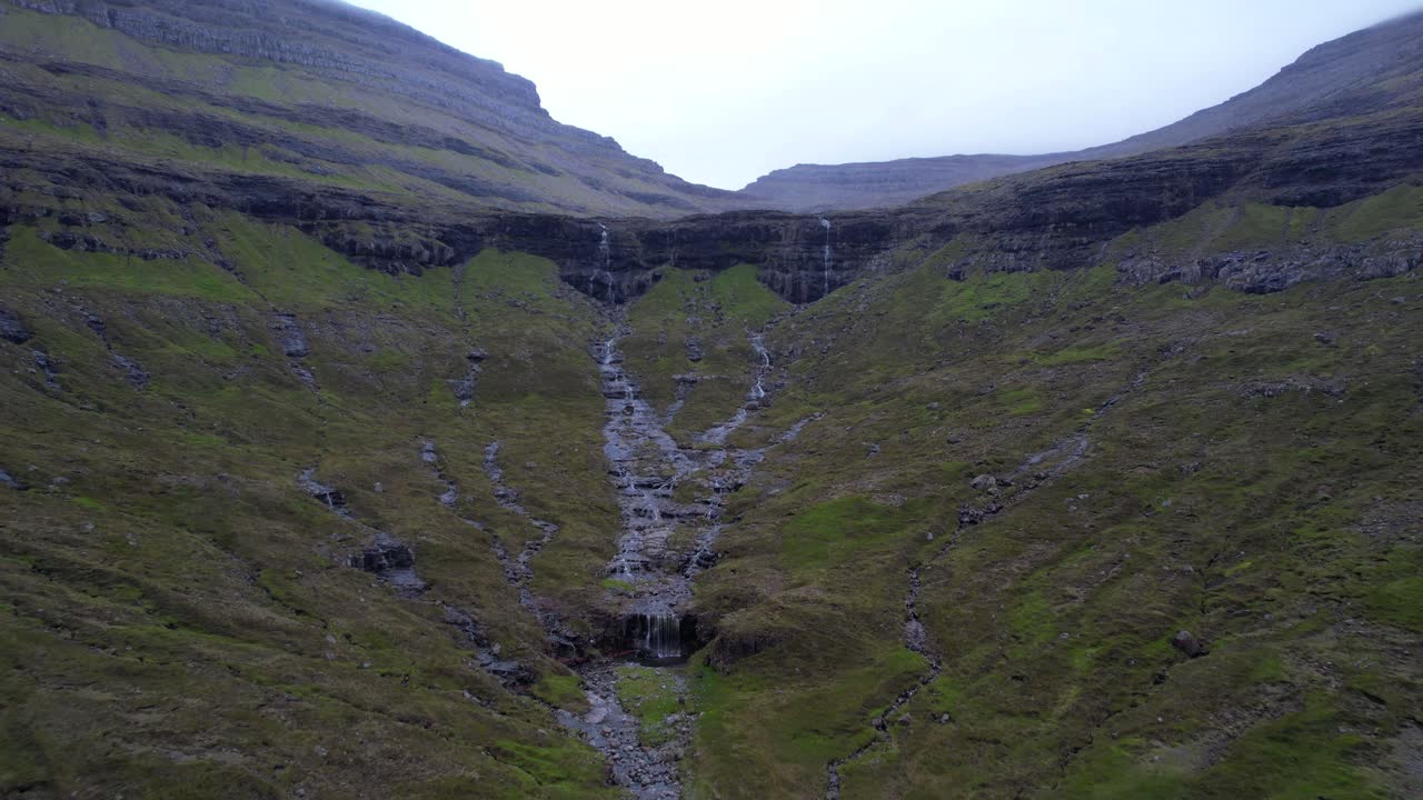 Piccole cascate che scendono dalle scogliere e convergono nella valle a Bordoy, Isole Faroe.