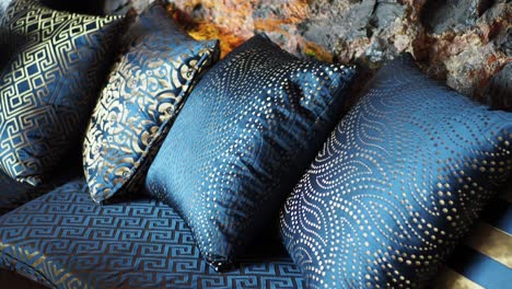 blue and gold decorated pillows on a sofa