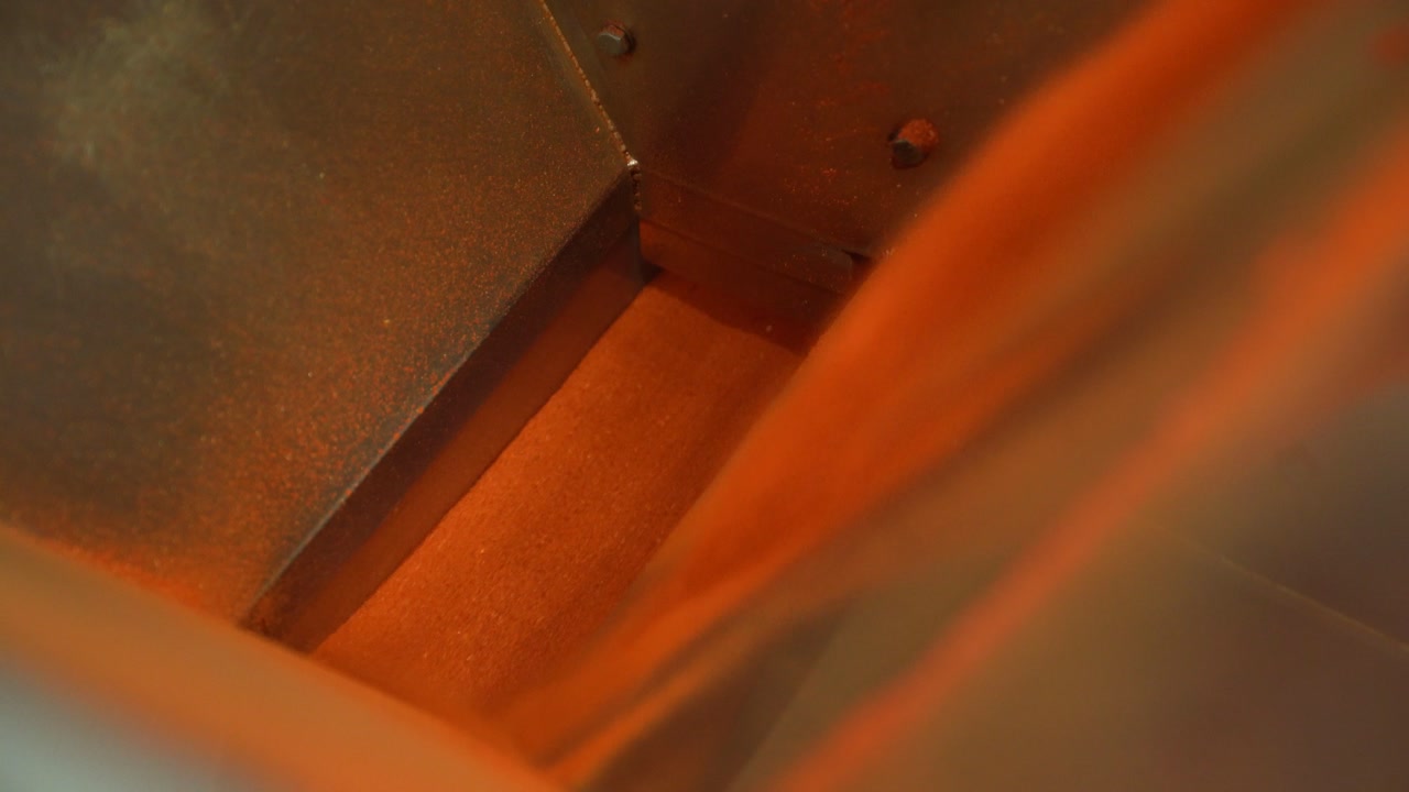 Ground pepper powder flowing inside industrial mill for spice production process