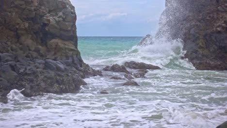 statische aufnahme von weißen wellen, die auf die felsige küste von banbanon beach, surigao del norte, philippinen, stürzen