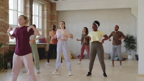 female coach and multiethnic people learning dance