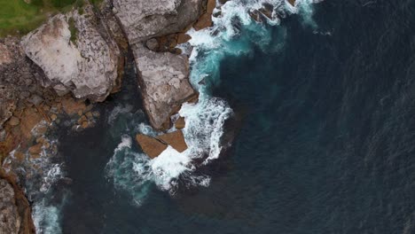 waves crashing on rocky shore of little bay beach in sydney, new south wales, australia - aerial top down