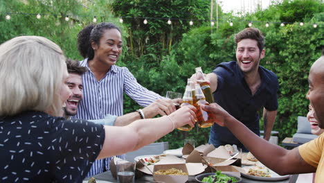 amigos haciendo tostadas con alcohol en el jardín en casa disfrutando de la fiesta de verano en el jardín