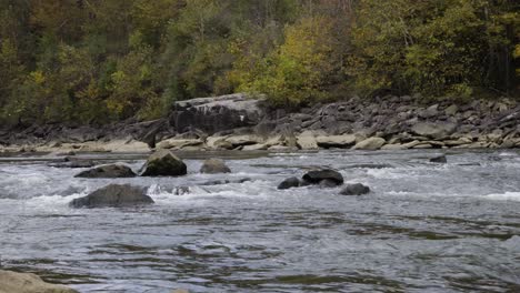 hand-held shot of the water flowing over rocks down through the river gorge