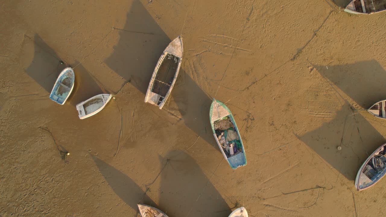 barcos de pesca varados en la arena durante la marea baja en el colorido amanecer