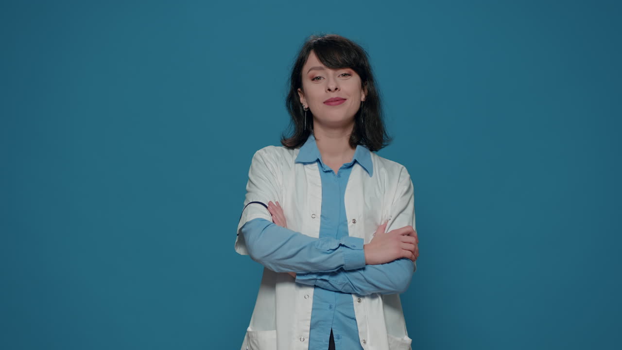 Portrait of woman scientist crossing arms over blue background