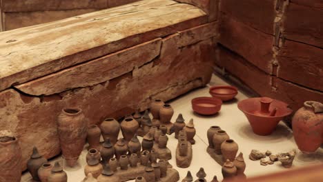 wooden coffin surrounded by historical pottery artifacts