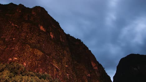 una vista de lapso de tiempo de una montaña en la parte inferior de machu picchu tomada de noche con maravilloso movimiento de nubes y estrellas en la noche