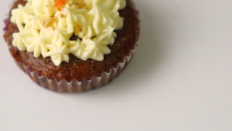 carrot walnut cupcake topped with icing, top view, studio shot