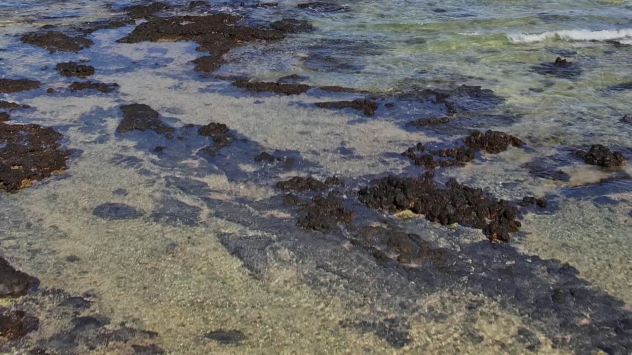 Persona che scatta foto sulla riva rocciosa nelle Isole Canarie durante il giorno.