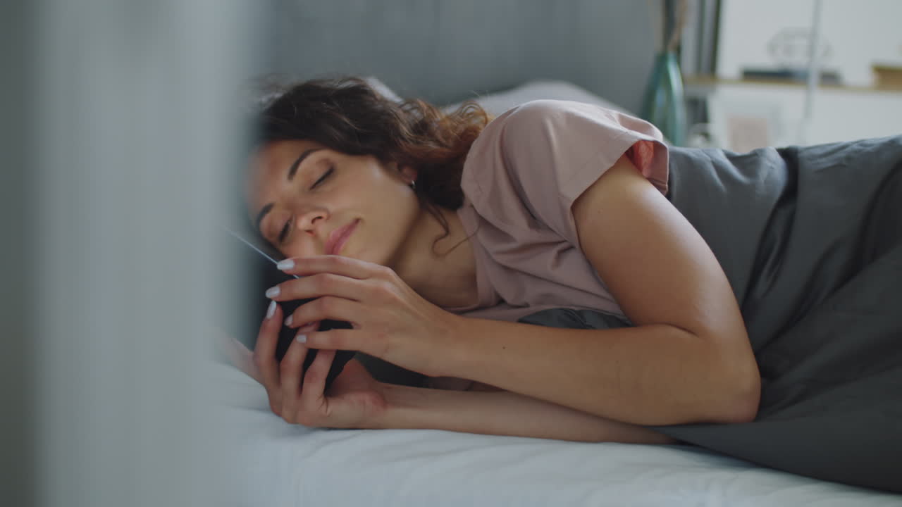 mujer usando el teléfono en la cama