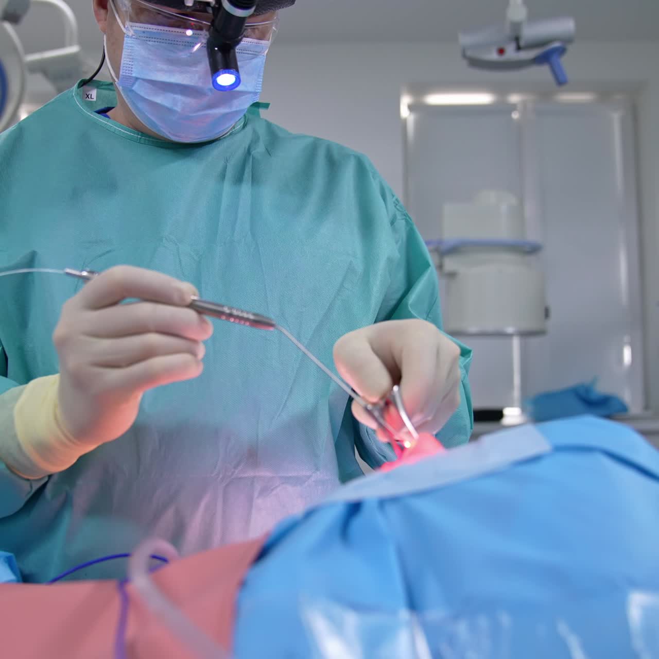Nasal surgery in modern clinic. Professional doctor performs surgery to a patient under general anesthesia. Surgical procedure with medical equipment