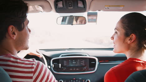 young white couple driving on highway, back view, close up