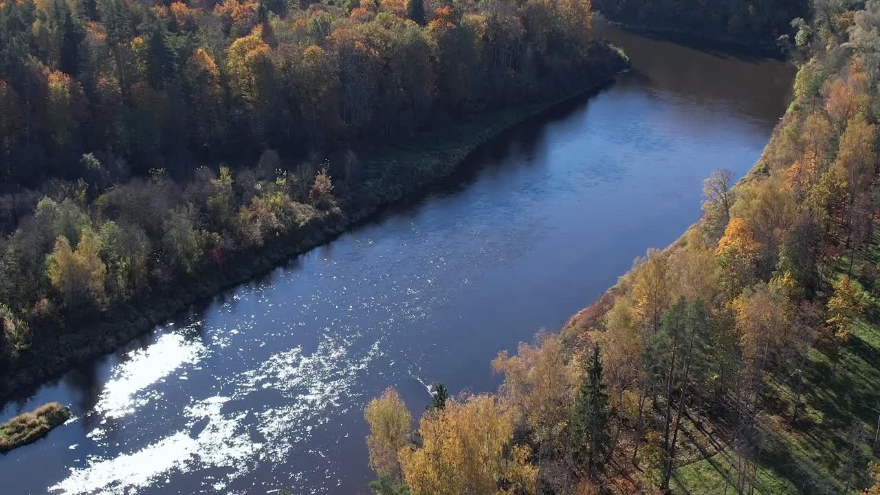 Syksyinen jokinäkymä Siguldassa, Latviassa, jossa on värikkäitä puita ja vettä