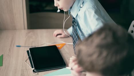 los alumnos, los niños pequeños, hacen sus tareas. uno de ellos hace un dibujo en un cuaderno.