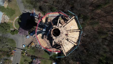 una vista aérea, de arriba hacia abajo directamente por encima de una torre de agua siendo desmantelada en un día soleado en long island, nueva york