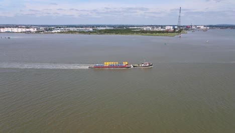 cargo ship vessel transporting shipping containers in uk, aerial