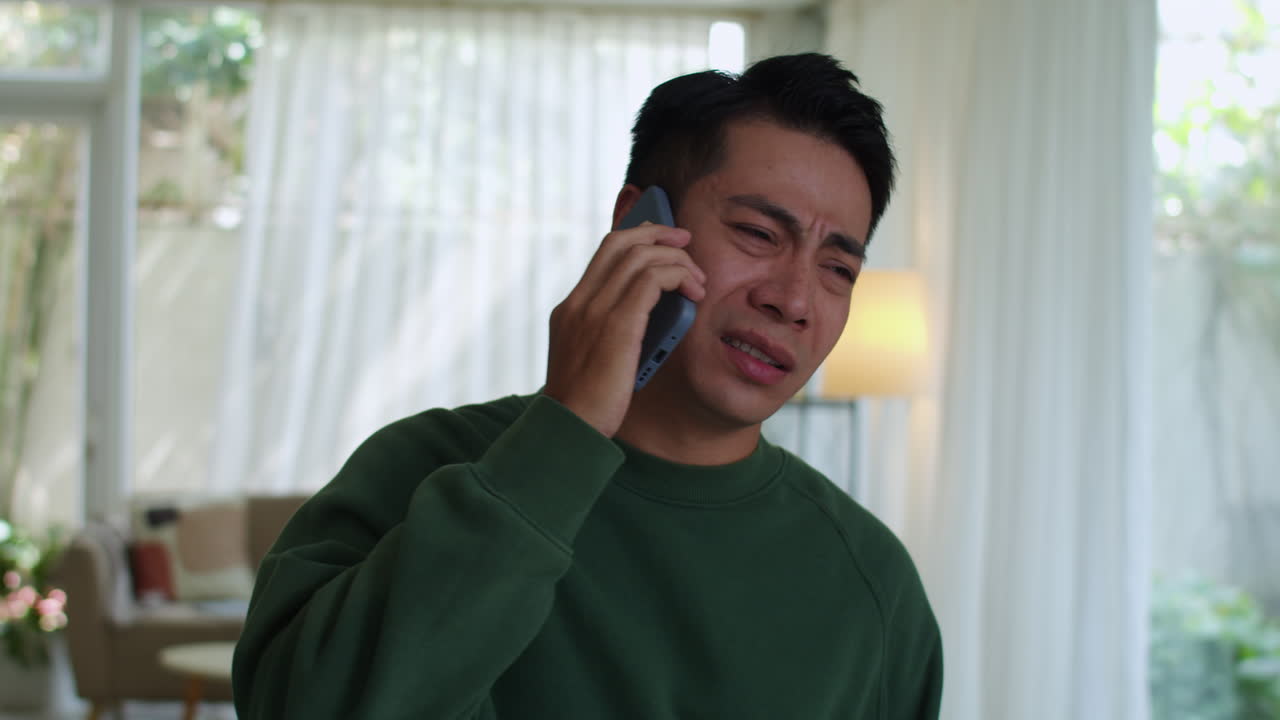 불행한 남자가 집에서 전화를 하고 있어