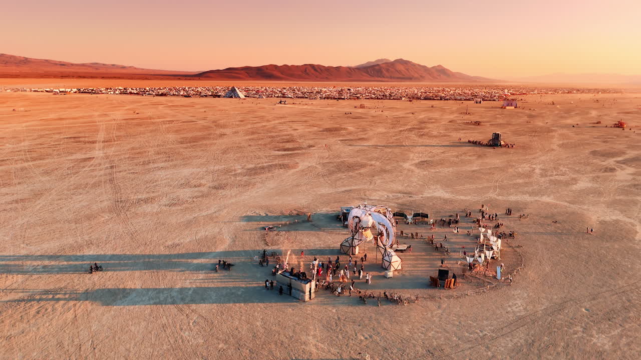 Nevada, USA, 22 August 2025: Burning Man desert camp at sunrise. Aerial view of Burning Man desert camp with art installations and mountains in the background at sunrise