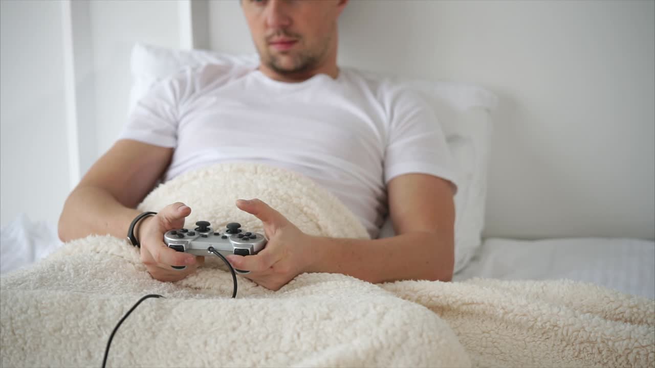 uomo che gioca a videogiochi a letto