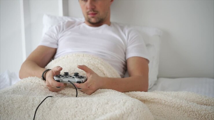 Man playing video game in bed