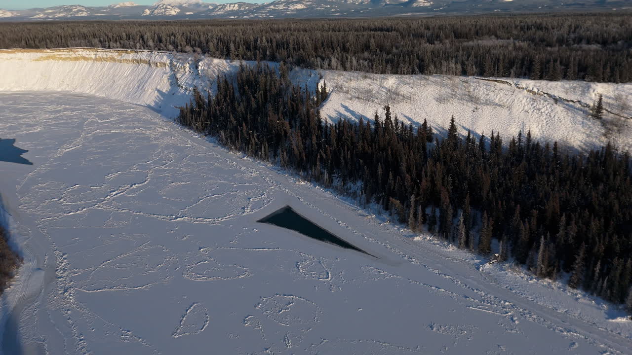 Frozen River During Winter Near Lake Laberge In Whitehorse, Yukon, Canada. Aerial Drone Shot