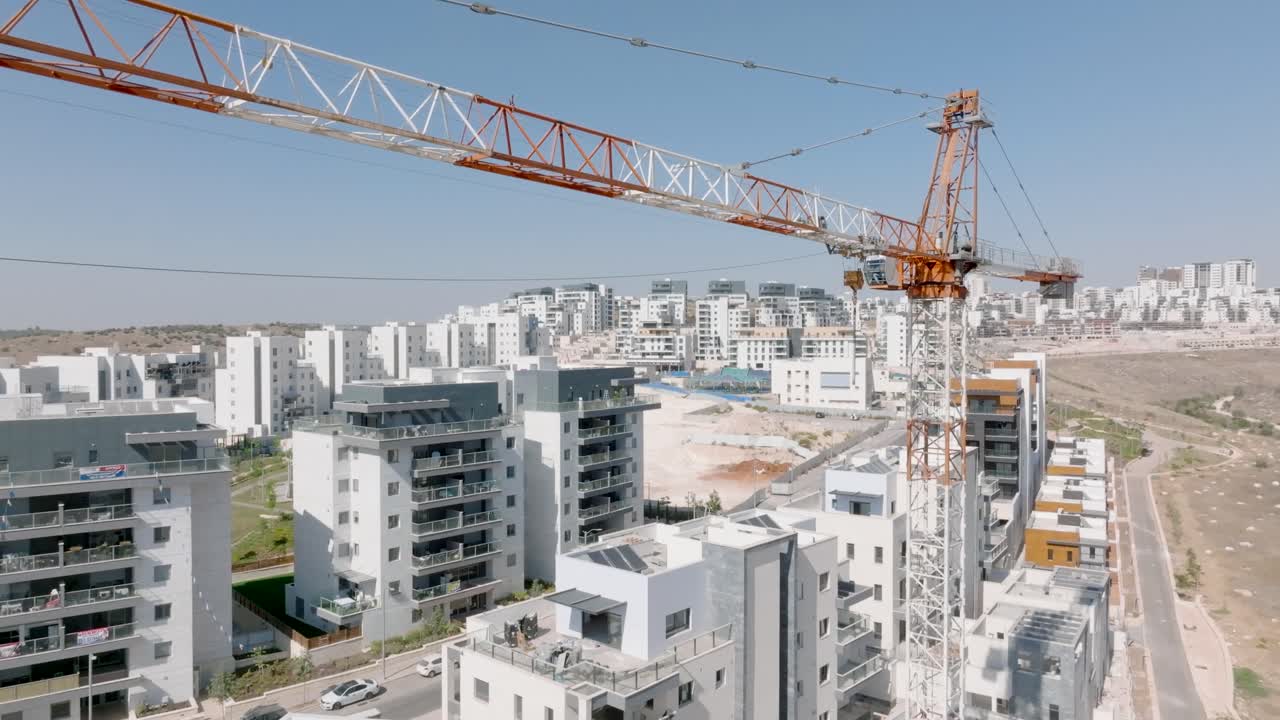 Filmato aereo 4K di un grande gru a torre in un cantiere edile in Israele. Il video mostra nuovi e moderni condomini in costruzione e l’espansione urbana.
