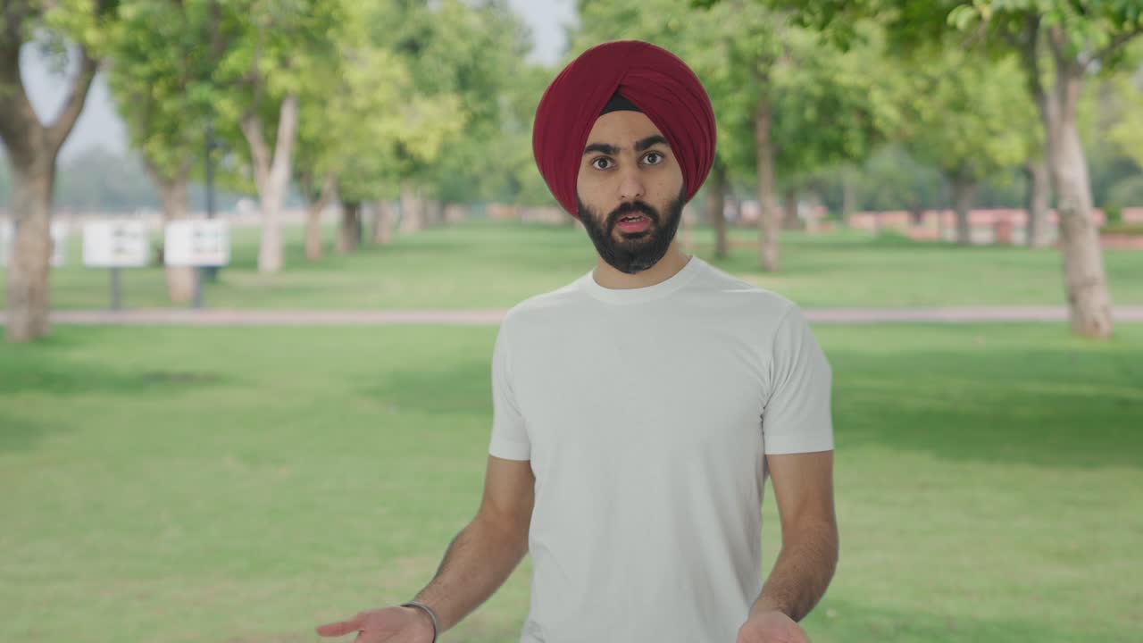 hombre indio sikh enojado luchando con alguien en el parque