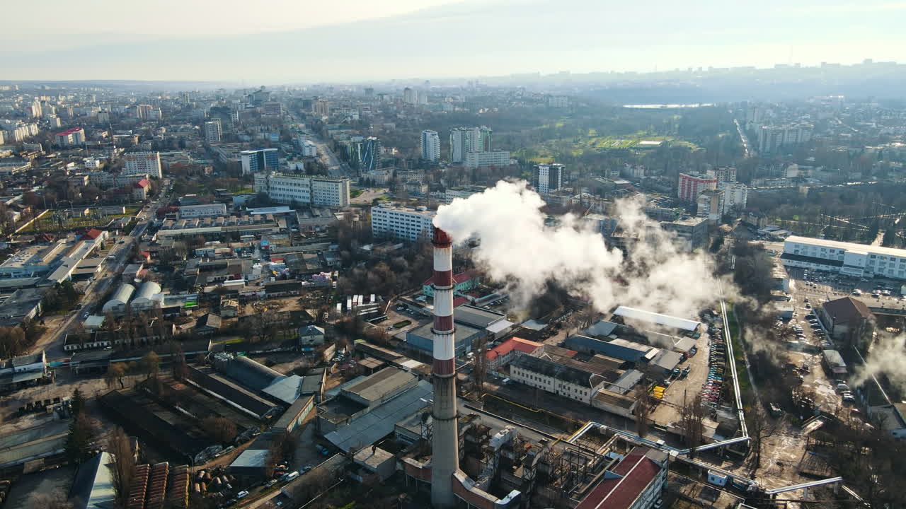 Aerial drone view of Chisinau. Thermal station with smoke coming out of the tube. Buildings, roads and bare trees. Good weather. Moldova