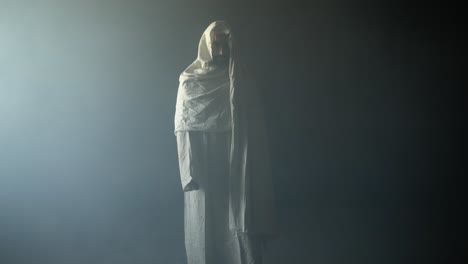 the resurrected jesus christ standing inside the tomb in bright, dramatic, contrast of darkness and holy light as representation of the easter sunday resurrection in cinematic slow motion.