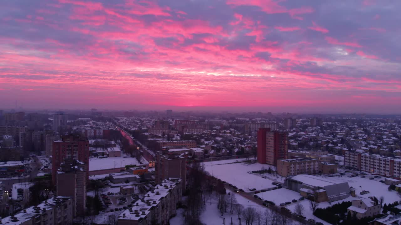 겨울에 아파트 주택의 공중 전망, 분홍색 서사시 하늘, 눈 덮인 환경, 아파트 바로 위를 날고, 확대하고, 리투아니아에서, 세상의 끝처럼 보입니다.