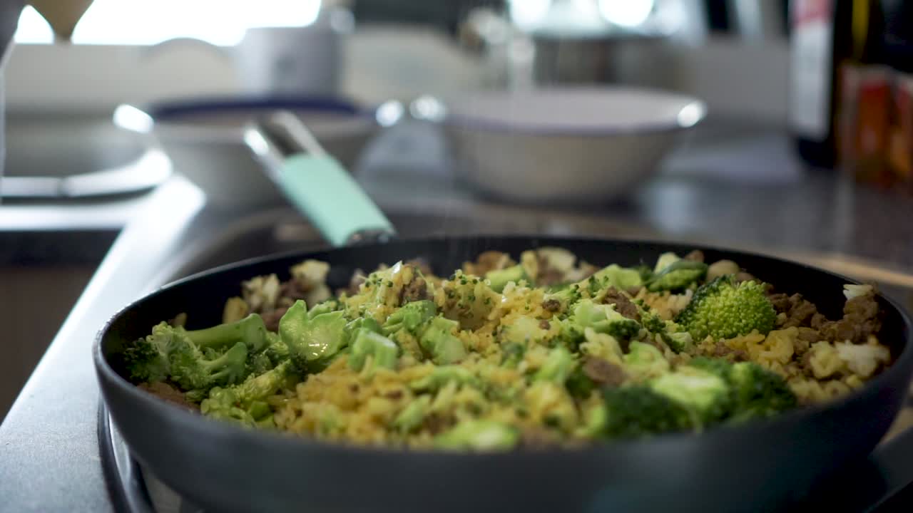 SLOWMO - Sprinkling salt on dish rice broccoli, curry and meat in kitchen of motorhome