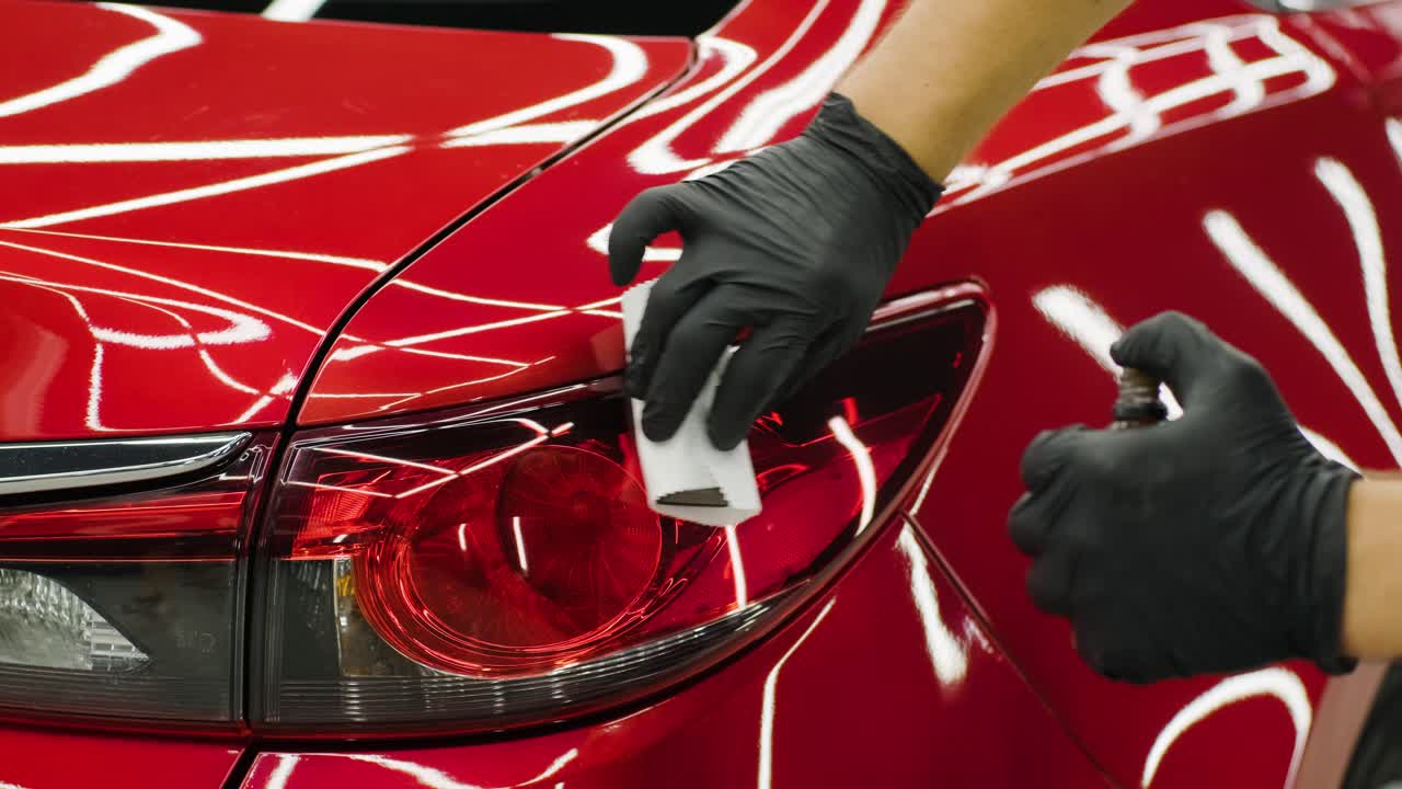 Car service worker applying nano coating on a car detail.