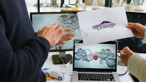 diseñadores de coches discutiendo en el escritorio en la oficina 4k