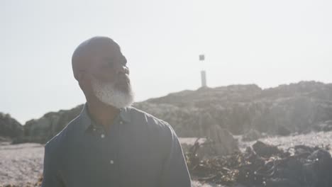 Senior-african-american-man-walking-at-beach,-copy-space,-slow-motion