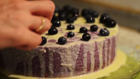 decorating a white chocolate cake with blueberries