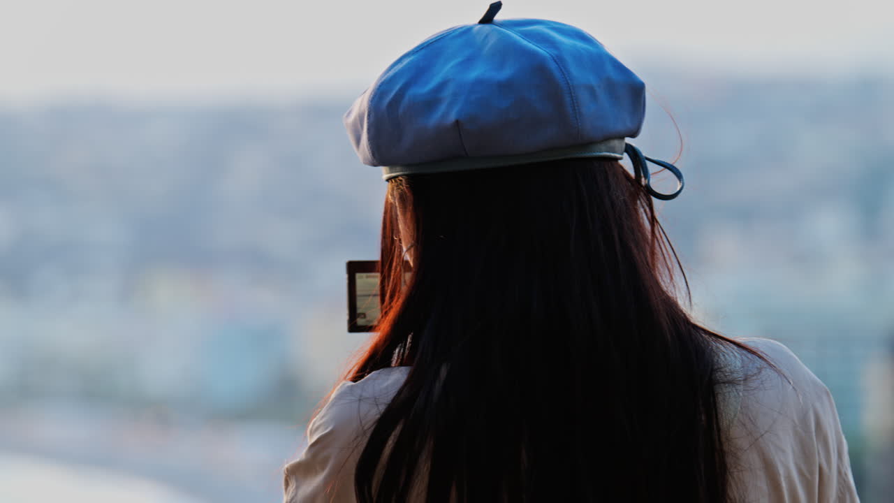 Woman in a blue beret taking pictures of the coast of France on a professional camera