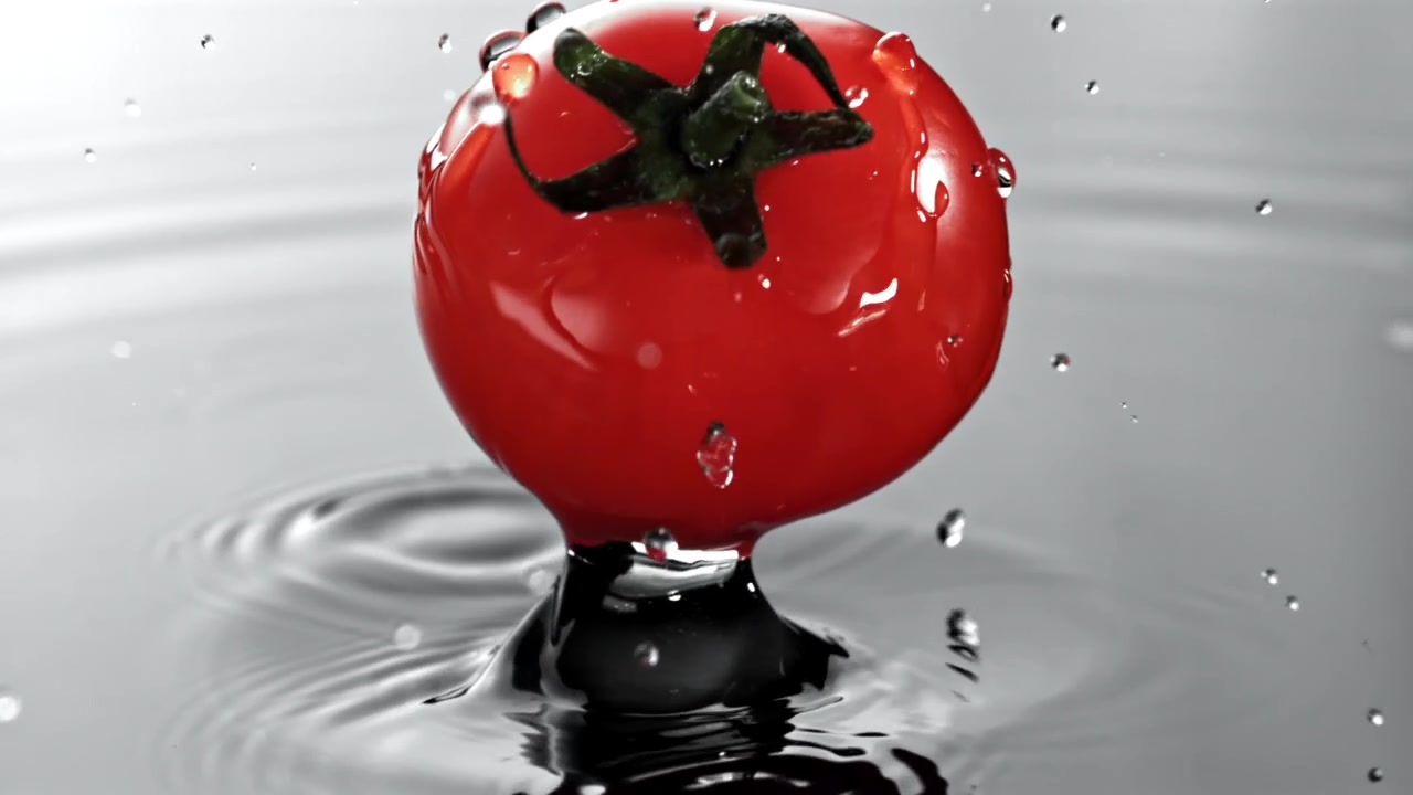Red Tomato Falling into Water in Slow Motion