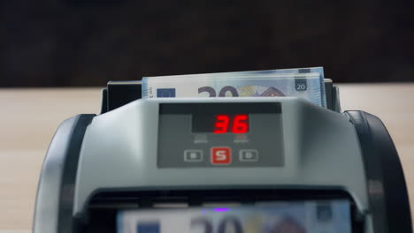 european currency counting electronic counter close up. hand putting cash money