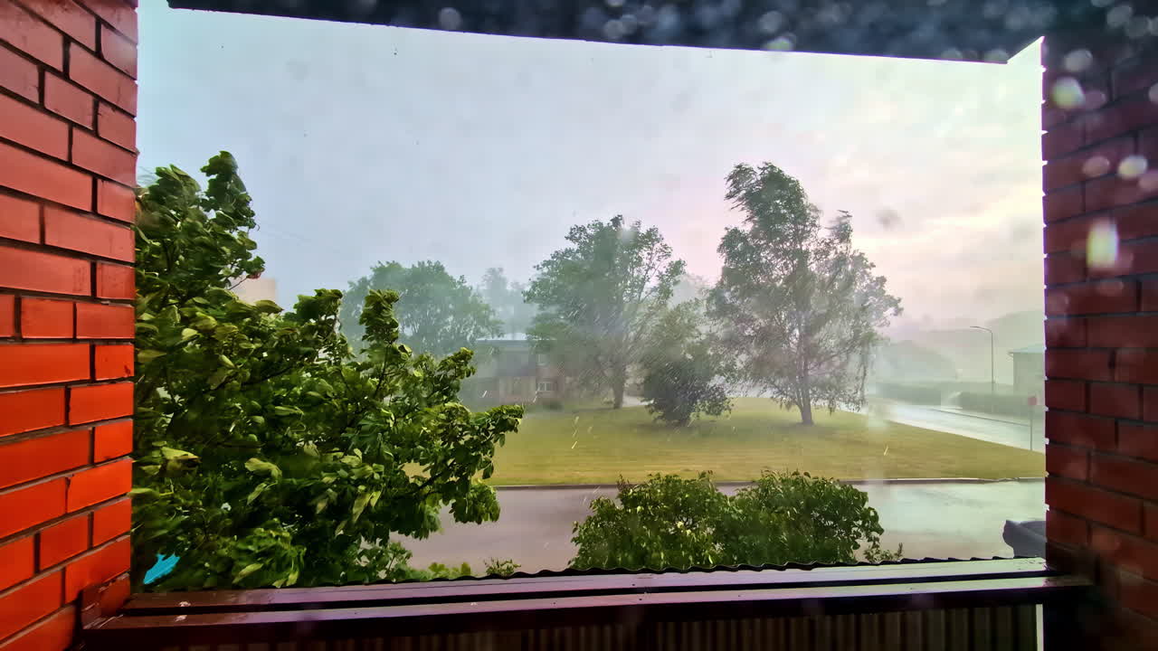 Heavy Rainstorm View From Brick Balcony With Wet Street and Windy Trees in Suburb
