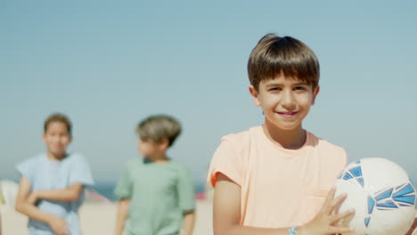 Slow-motion-of-smiling-boy-holding-soccer-boy-in-hands