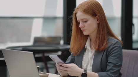 woman is working with laptop remotely in cafe sending message by smartphone and checking notice in mobile phone