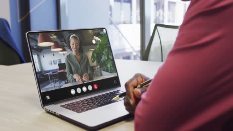 African-american-man-using-laptop-for-video-call,-with-business-colleague-on-screen